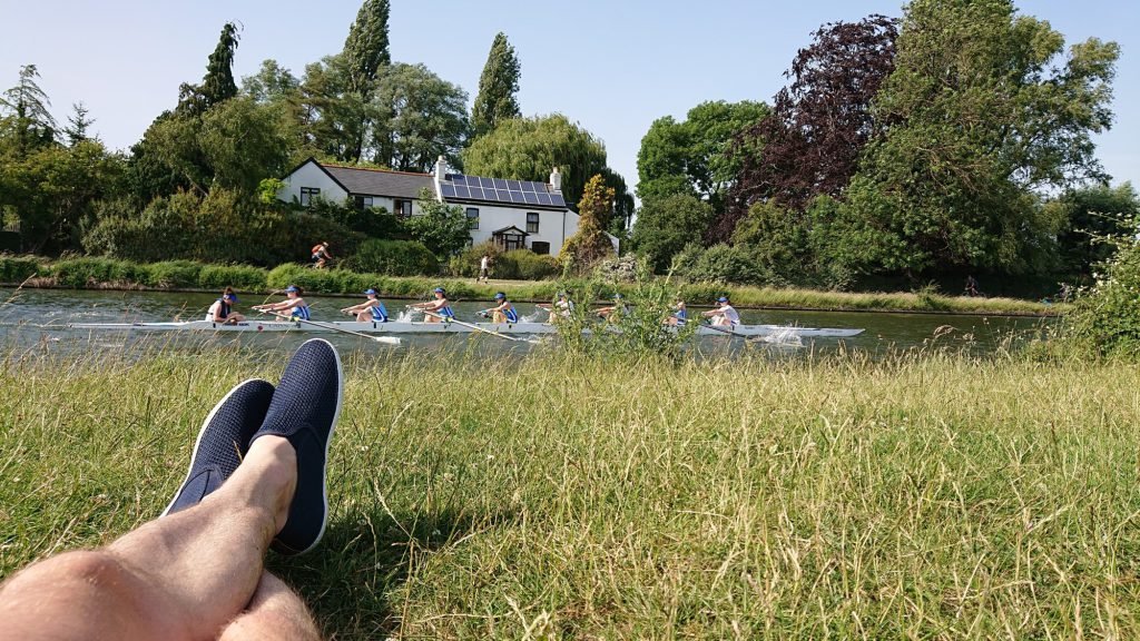Rowers passing on the River Cam, seen from the riverbank